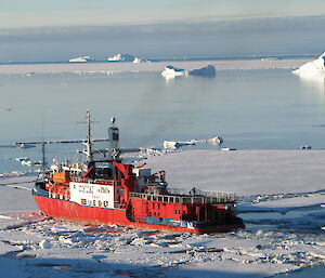 Red and white ship in ice