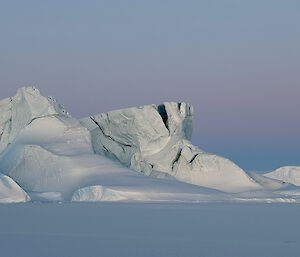 Ice features projecting from the sea ice, with dark cracks and crevasses visible