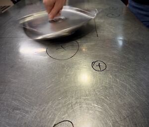 A kitchen bench with white-board pen markings identifying where dents are located on the kitchen table top