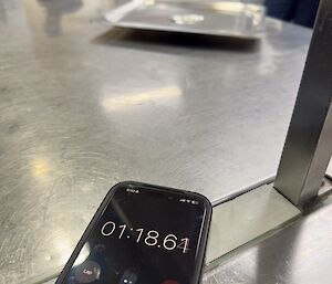 a stopwatch timing the lid spin, with the lid in the background