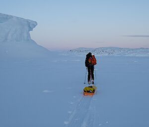 an expeditioner treks through a snowy landscape