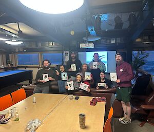 A group of people pose with their artwork in a lounge area