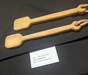 Two carved wooden salad spoons sit on a black cloth