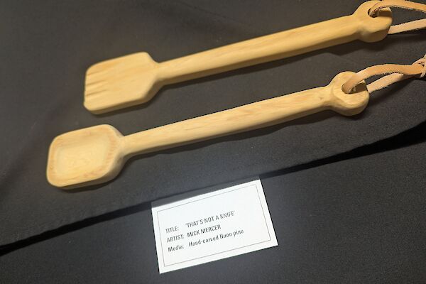 Two carved wooden salad spoons sit on a black cloth