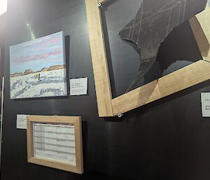 Various artworks are hung on a black background