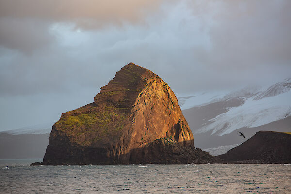 A large rock formation bathed in golden light