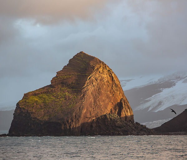 A large rock formation bathed in golden light