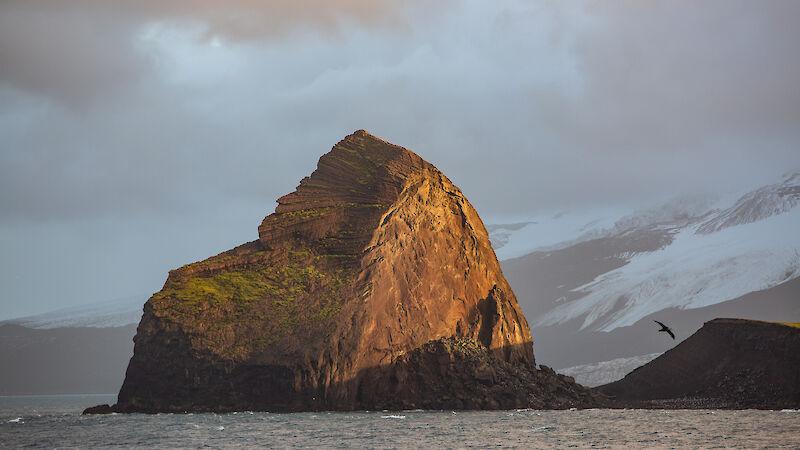 A large rock formation bathed in golden light