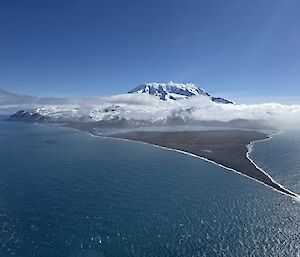 A snow covered volcano rising from the sea