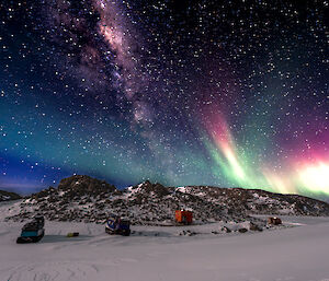 A photo of the night sky auroras and stars over Colbeck Hut