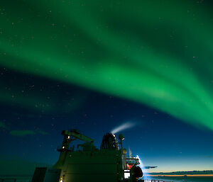 A photo of a green aurora overhead while on the upper decks of the Nuyina