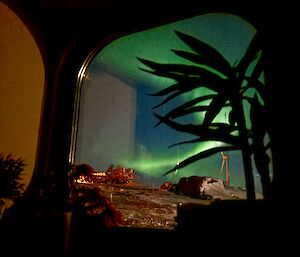 A photo looking outside a bedroom window, with aurora outside