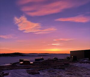 A picture of an orange/purple sunset with polar stratospheric clouds in the sky