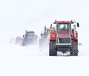 White conditions with a line of snow tractors arriving