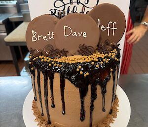A picture of a very large/tall chocolate indulgence birthday cake