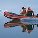 Two expeditioners in an inflatable rubber boat transporting equipment