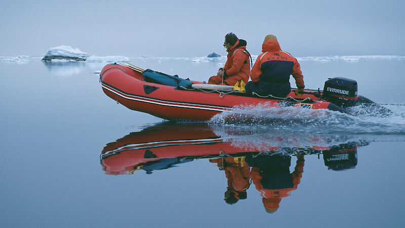 Two expeditioners in an inflatable rubber boat transporting equipment