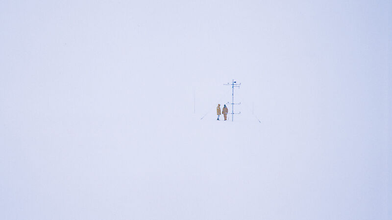 In whiteout conditions, company representatives inspect an automatic weather station close to the proposed airfield site