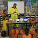 Scientist in a freezer suit demonstrating to school students how to make glacier goo