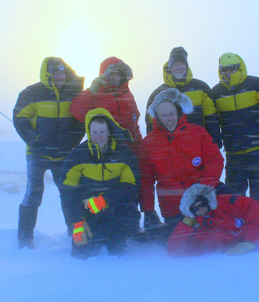 Ice core drilling team pose together in a blizzard at Law Dome