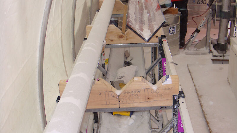 Scientist with an ice core inside the drill tent at Law Dome