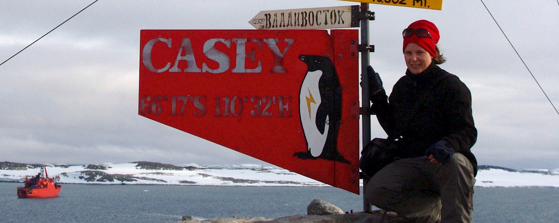 Susan Doust beside the signpost at Casey station.