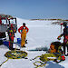 Divers and support crew prepare for a dive through a hole in the ice in Antarctica