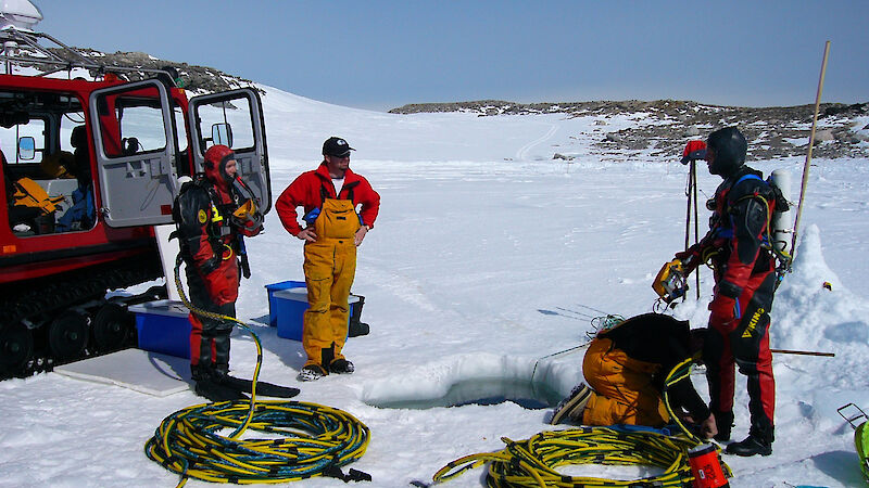 Divers and support crew prepare for a dive through a hole in the ice in Antarctica