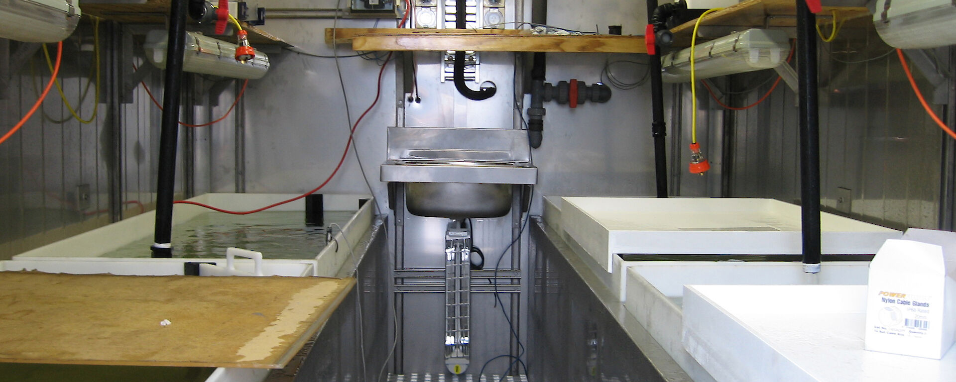 Four seawater tanks are visible inside the aquarium with small heaters on the shelves above.