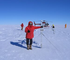 Expeditioner in ice field with helicopter in background