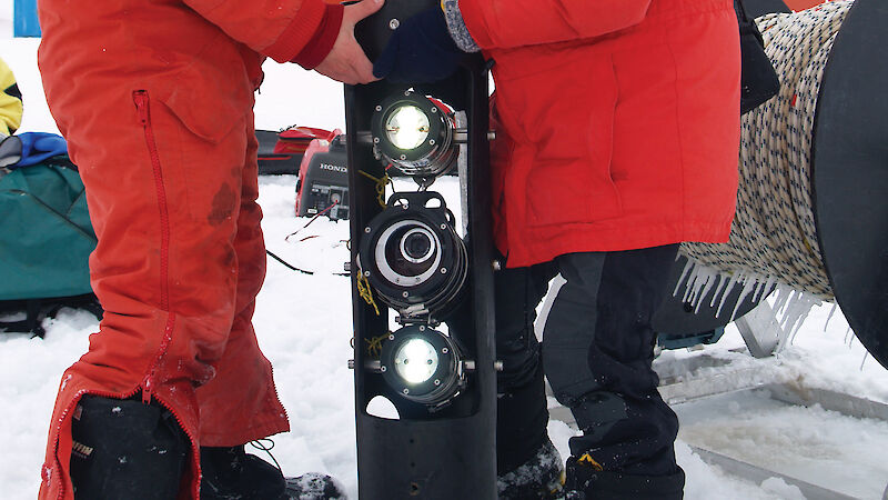 SIPEX scientists deploy a high definition video camera and lamp system to study krill under the sea ice.