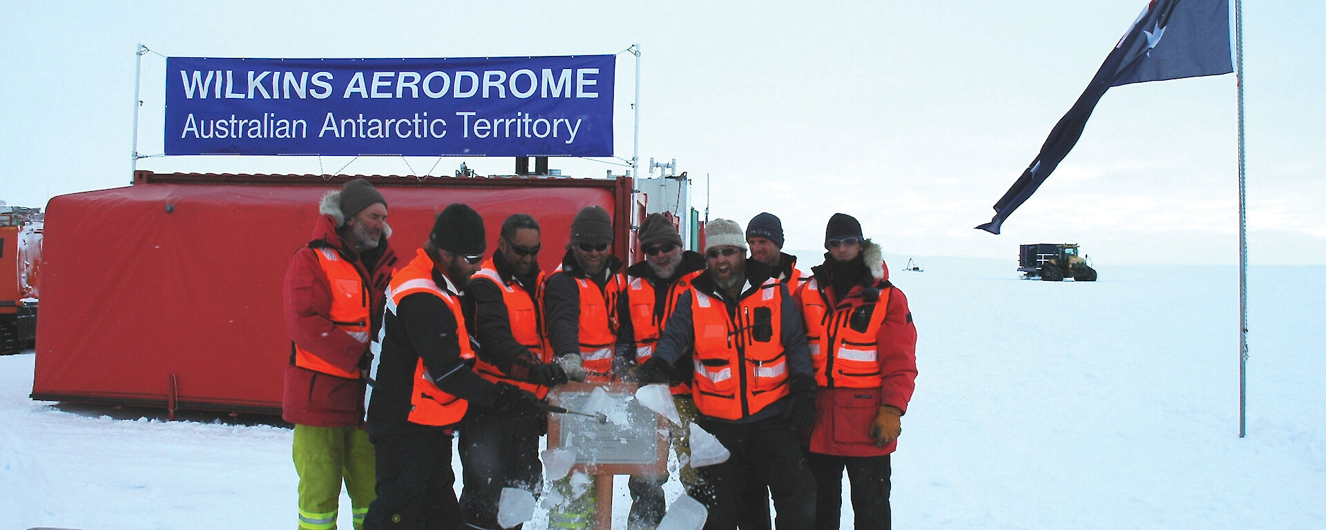 The Wilkins Runway crew unveil a plaque commemorating the opening of the runway