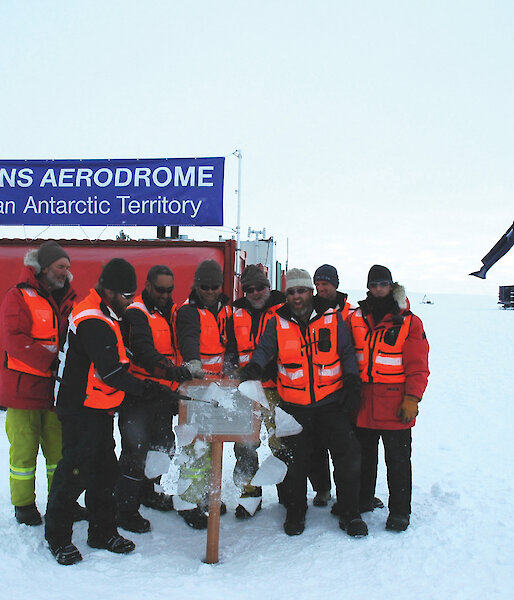 The Wilkins Runway crew unveil a plaque commemorating the opening of the runway