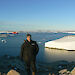 Expeditioner at Casey with harbour and Aurora Australis in background