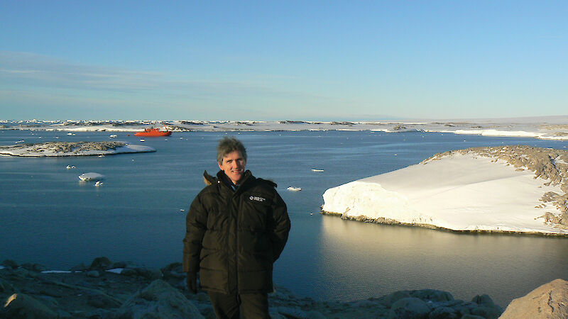 Expeditioner at Casey with harbour and Aurora Australis in background