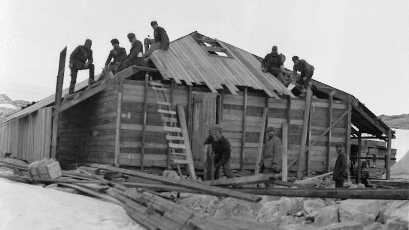 Mawson’s huts construction with workers on the roof and around the hut