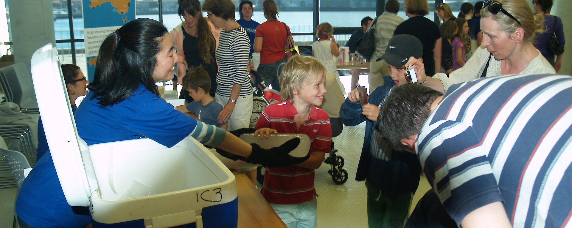 IMAS PhD student Mana Inoue shows an Antarctic ice core to children and parents