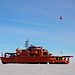 On the unscheduled Voyage 6, cargo was delivered to Mawson station using four AS350 B3 helicopters. The helicopter pictured here is taking a sling load of fuel in an Intermediate Bulk Container to the station.