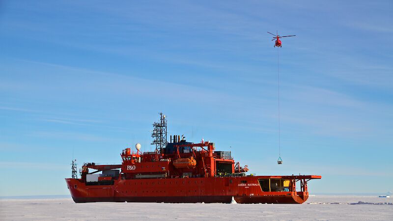 On the unscheduled Voyage 6, cargo was delivered to Mawson station using four AS350 B3 helicopters. The helicopter pictured here is taking a sling load of fuel in an Intermediate Bulk Container to the station.