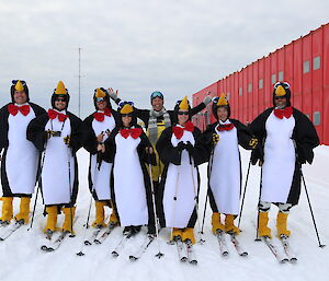 Seven Casey station expeditioners in their penguin onesies