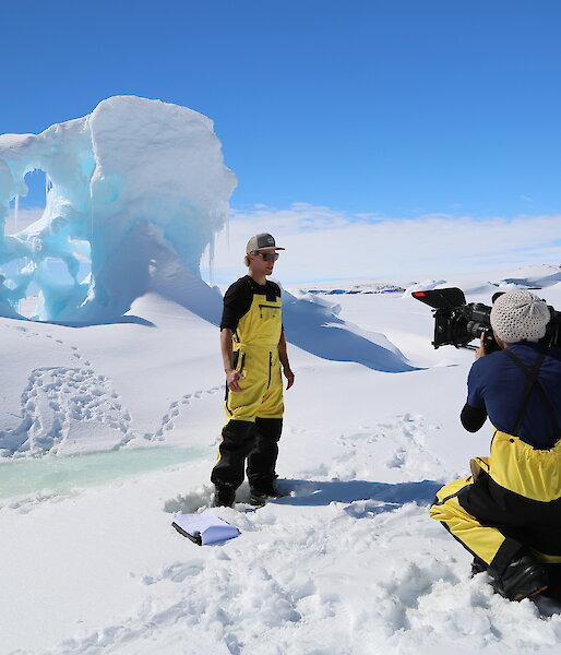ABC3 presenter Kayne Tremills and cameraman Josh Zaini film a segment for the new Australian children’s television show Antarctica: Secrets of the Giant Freezer, standing in front of an ice formation