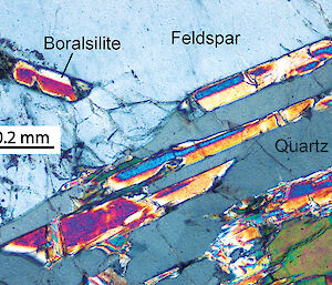 Photomicrograph of striped boralsilite prisms