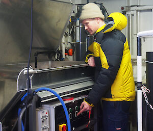 Rob King standing at a modified fish pump set up onboard the ship.