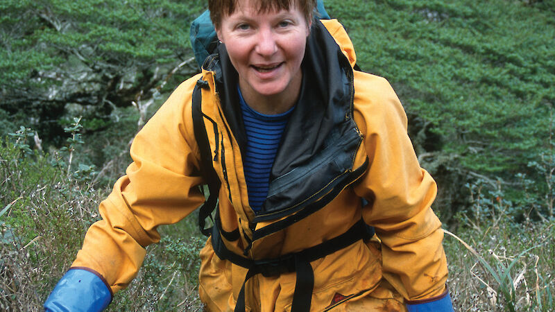 Barbara climbs a steep, thickly vegetated hill on the Argentine island Diego de Almagro.