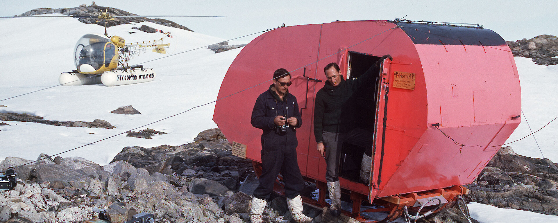 Two expeditioners stand in front of Aneata at Haupt Nunatak in 1964.