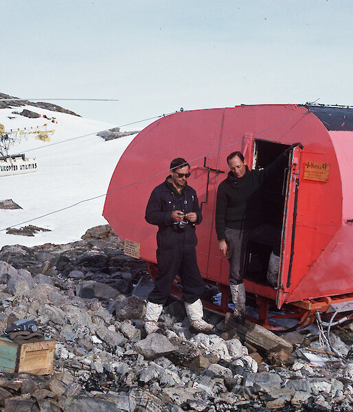 Two expeditioners stand in front of Aneata at Haupt Nunatak in 1964.