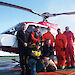 The Antarctic aerial survey team standing beside a helicopter in Antarctica.