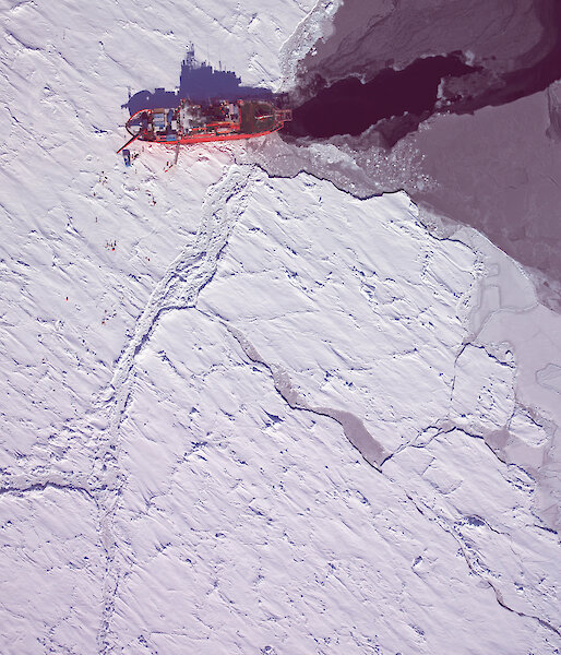 An aerial photograph taken with the high resolution digital camera in the helicopter, showing part of a survey area or Â‘transectÂ’ to the left of the ship with scientists working on the ice.