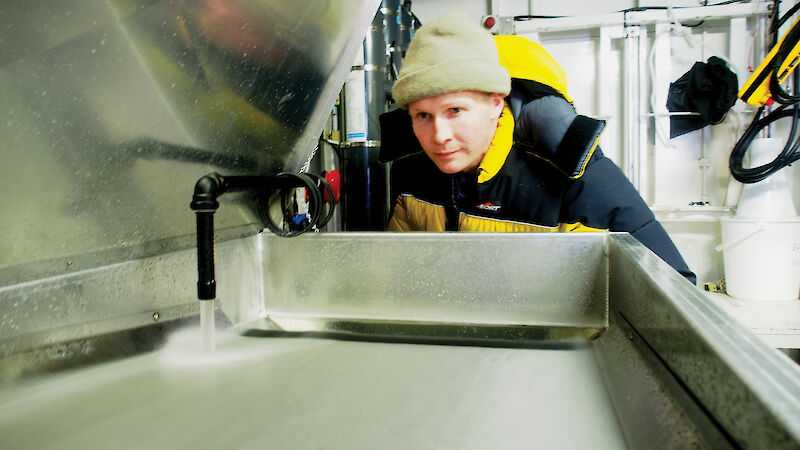 Australian Antarctic Division krill aquarium manager Rob King catching krill in the Antarctic sea ice zone ocean using a fish pump.