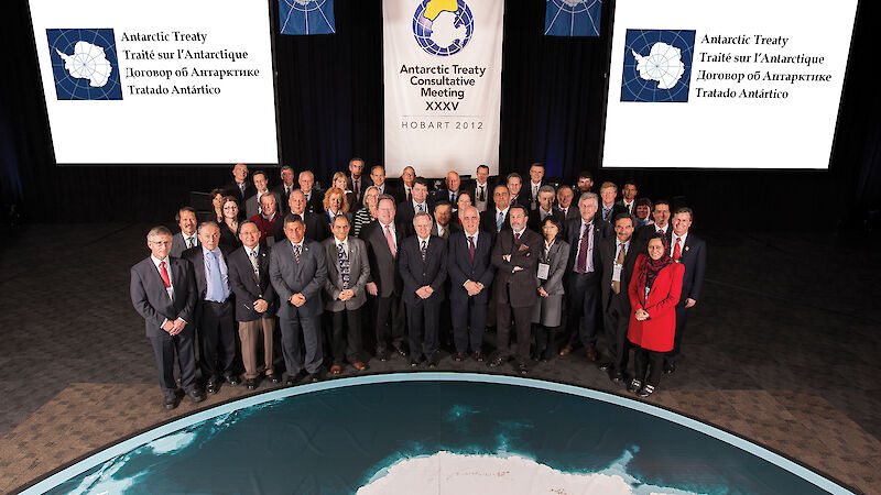 Antarctic Treaty consultative meeting Heads of Delegations gather in front of the giant floor map of Antarctica.